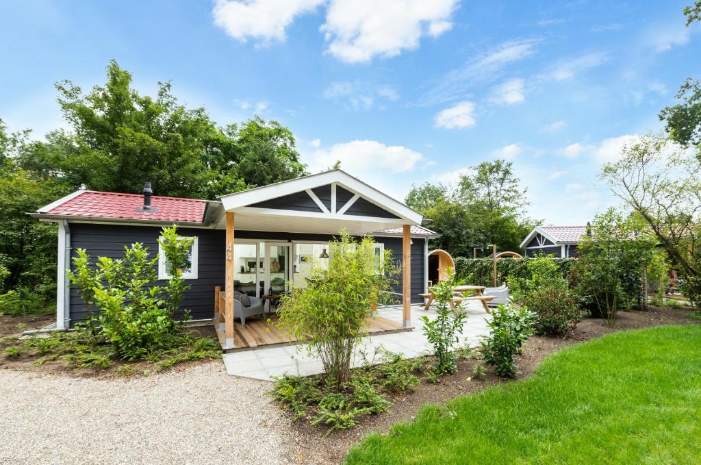 a tiny house with a large deck in a garden at De Krakeling in Zeist