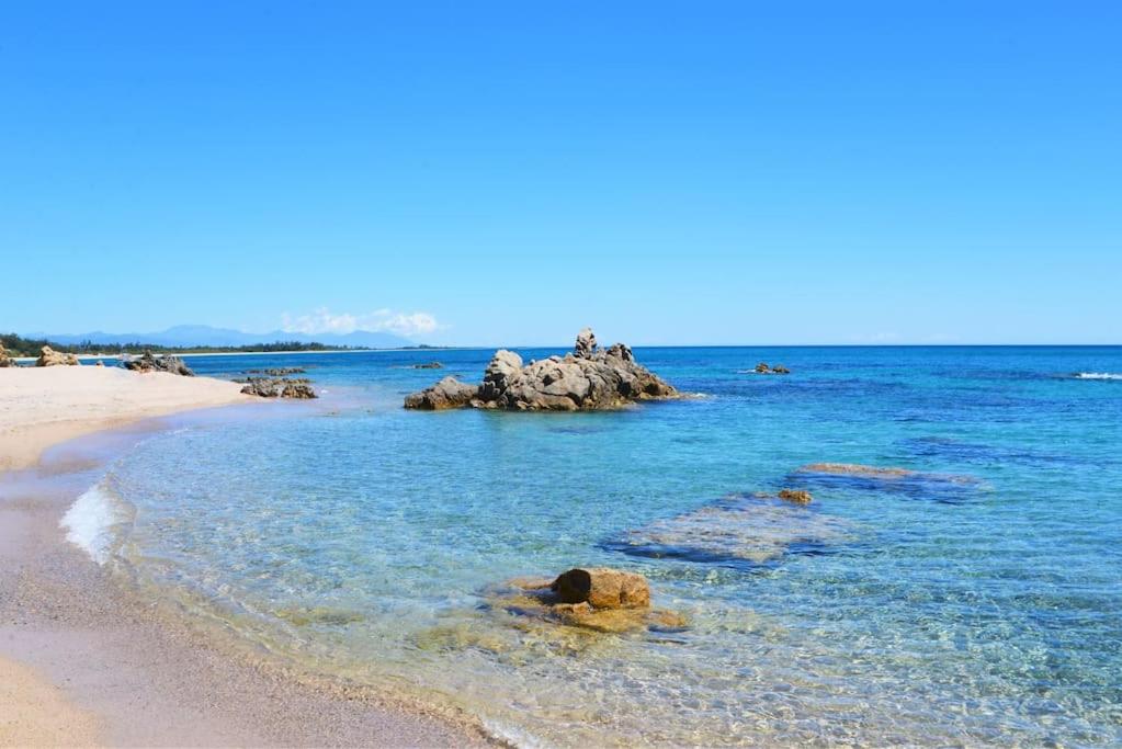 - une plage avec des rochers dans l'eau dans l'établissement Charmant studio sur le port, à Kamiesch