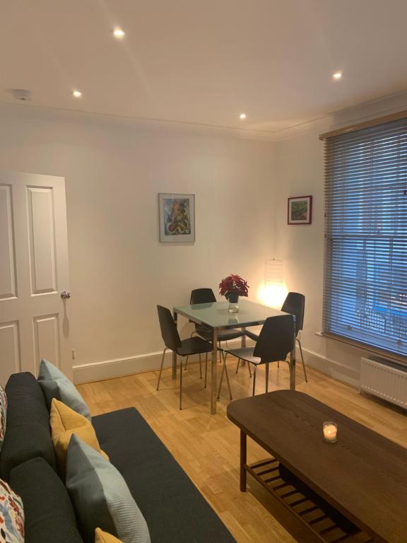 uma sala de estar com um sofá e uma mesa em Beautiful one bedroom flat in the heart of Notting Hill Gate em Londres