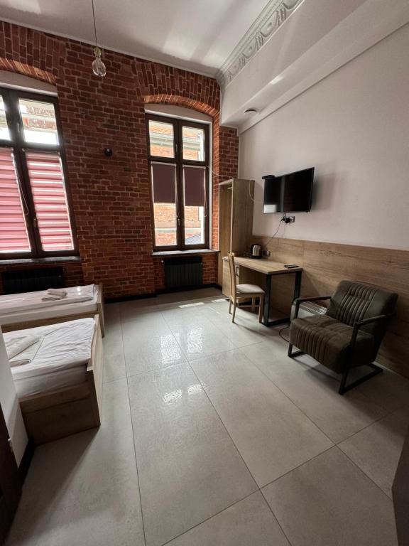 um quarto com uma secretária, uma cadeira e uma mesa em Aparthotel Łódź 55 Piotrkowska em Lódź