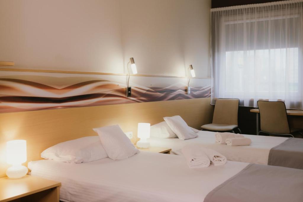 Quality Silesian Hotel في كاتوفيسي: غرفة فندقية بسريرين و كرسيين