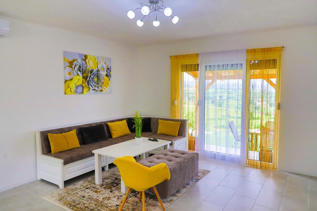 - un salon avec un canapé, une table et des chaises jaunes dans l'établissement Villa Bubinka, à Bihać