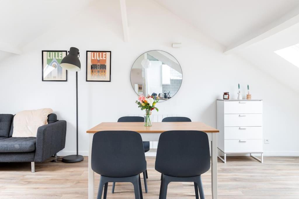 - une salle à manger avec une table, des chaises et un miroir dans l'établissement Appartement agréable et spacieux 2 chambres 2 SDB - Lille, à Lille