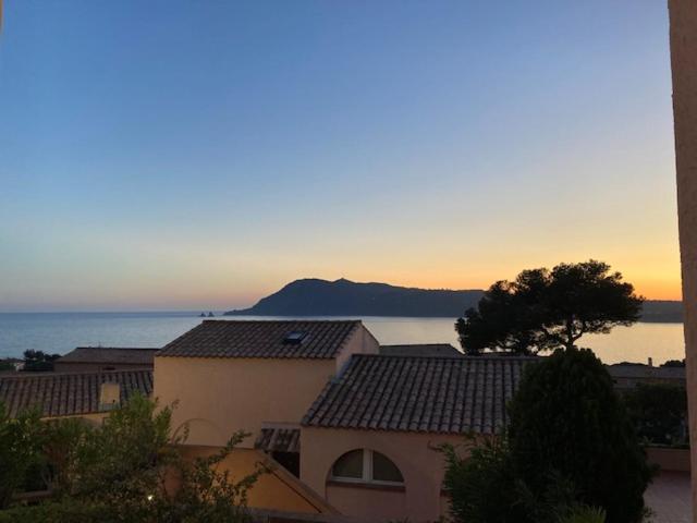 - une vue sur une maison avec l'océan en arrière-plan dans l'établissement La mer sans voiture ! 2 e-bikes à louer, vue sublime, 40 m2, à Saint-Mandrier-sur-Mer