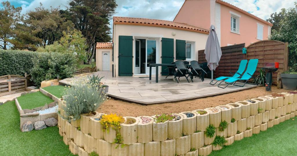 a backyard with a table and chairs and a fence at maison 300m mer à Brétignolles-sur-Mer (La Parée)- Calme in Brétignolles-sur-Mer