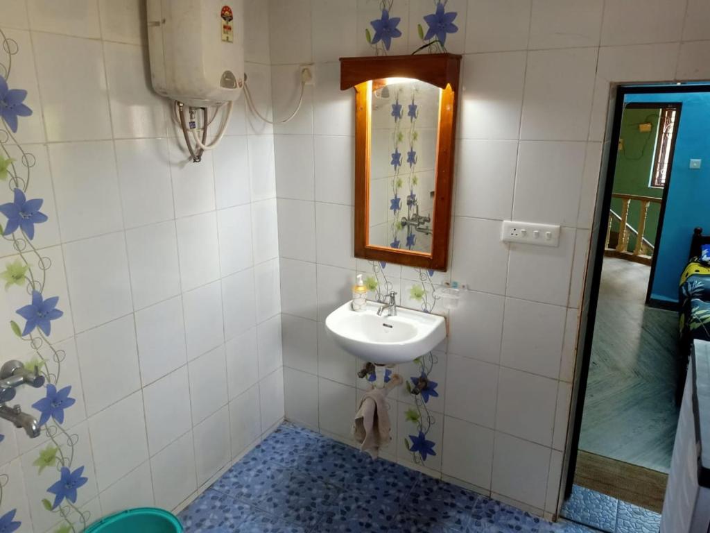 ein Bad mit einem Waschbecken und einem Spiegel in der Unterkunft Villa westcost tembewadda colomb in Canacona