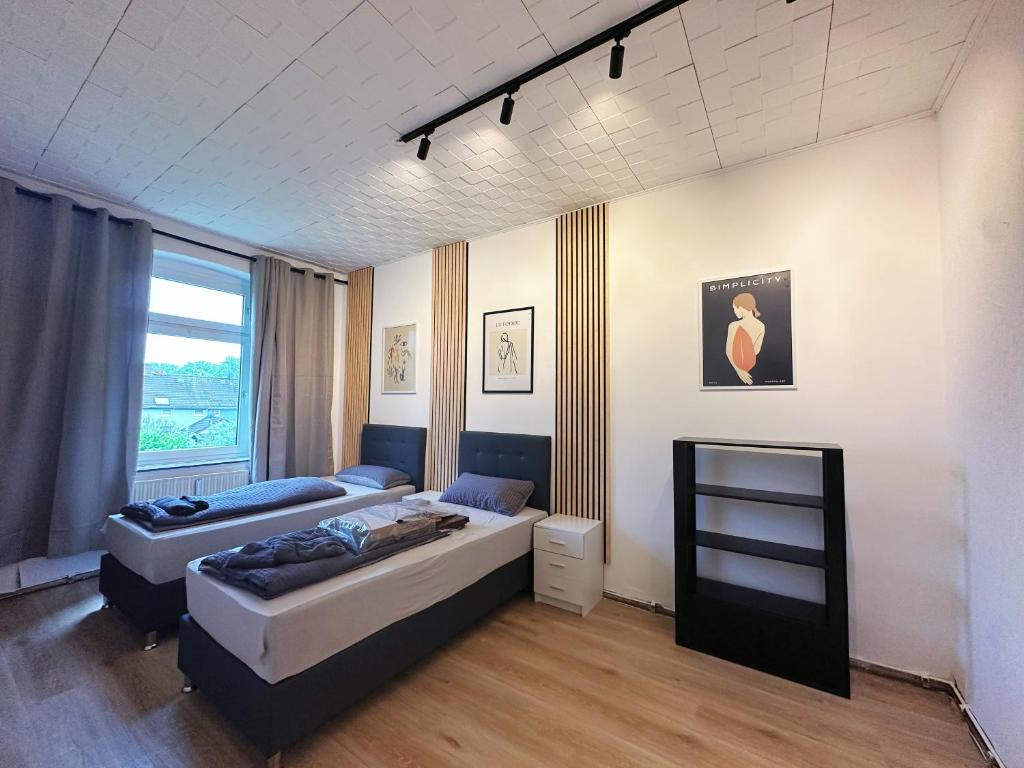 1 dormitorio con 2 camas y ventana en 2 Schlafenzimmer 5 Betten, en Duisburg