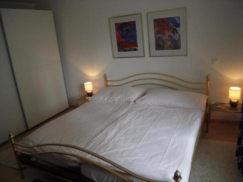 ein Schlafzimmer mit einem Bett mit zwei Lampen an zwei Tischen in der Unterkunft Appartement Alpenblick A1 in Weggis