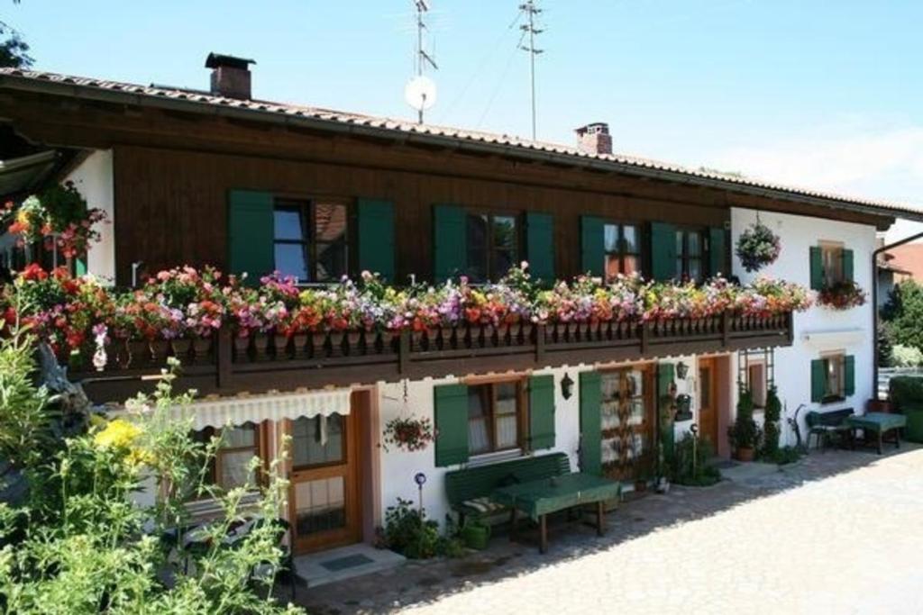 a house with flowers on the balcony at Ferienwohnung in Bad Bayersoien mit Terrasse, Grill und Garten in Bad Bayersoien