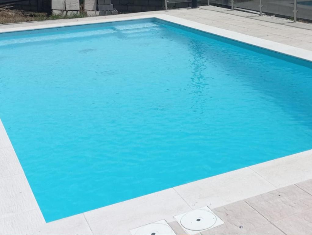 a swimming pool with blue water in a yard at Piscina privada - V3 - Internet Fibra in Teixoso