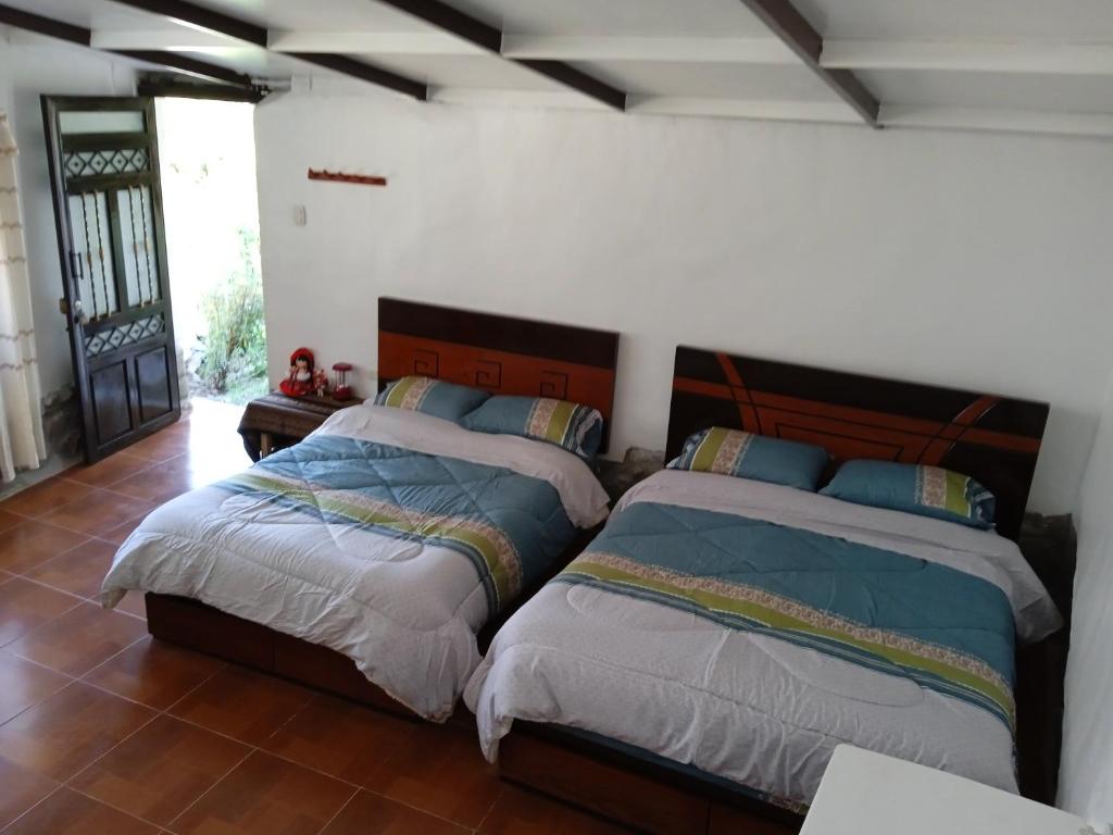 1 dormitorio con 2 camas en una habitación en casa montañista lodge & camping, en Huaraz