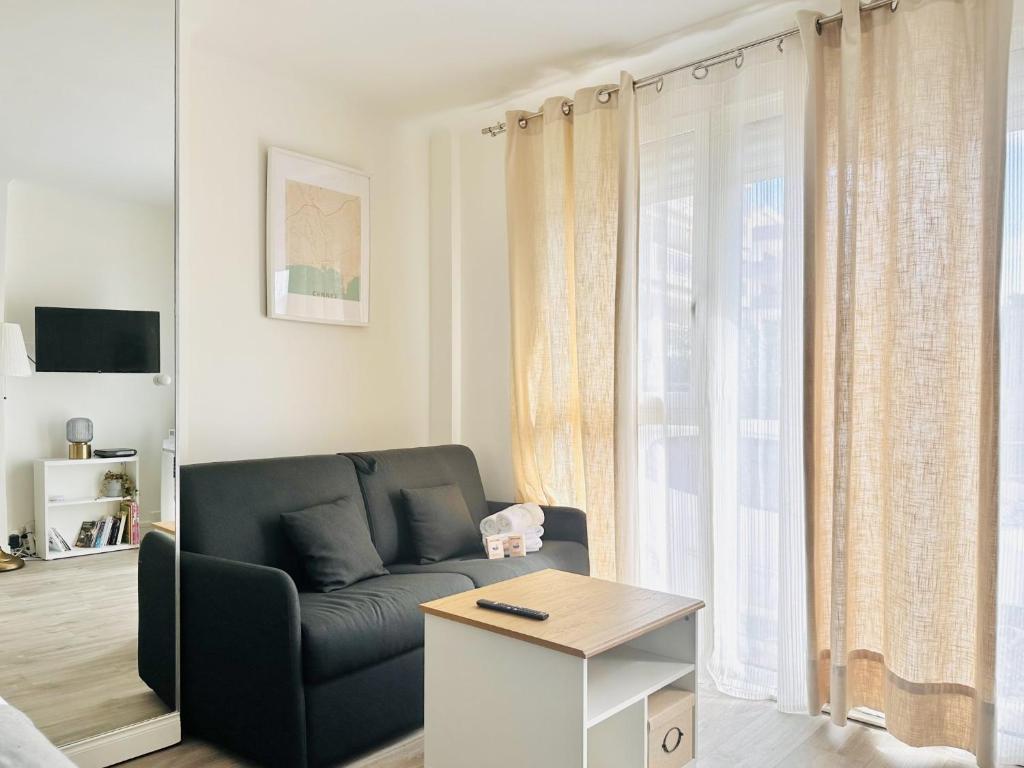 un salon avec un canapé et une fenêtre dans l'établissement Le Palm Beach - Bord de mer - Cannes, à Cannes