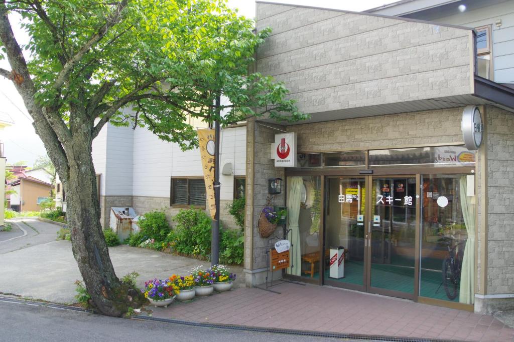 a store front with a tree in front of it at Hakuba Ski-Kan in Hakuba