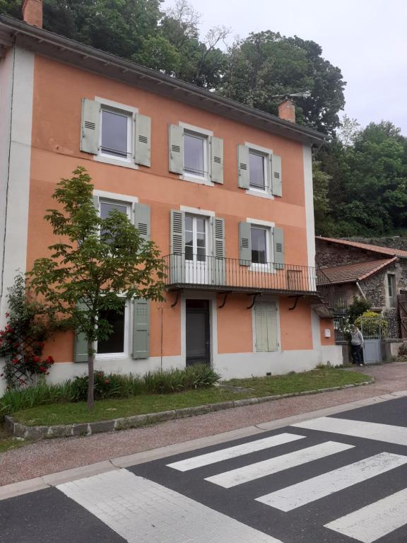 een oranje en wit gebouw aan de straatkant bij Les Terrasses du Verger in Monistrol-dʼAllier