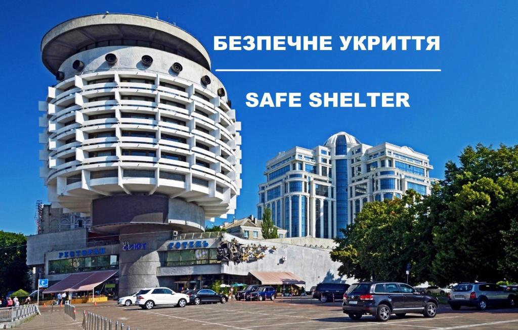 un edificio con coches estacionados en un estacionamiento en Salute Hotel, en Kiev
