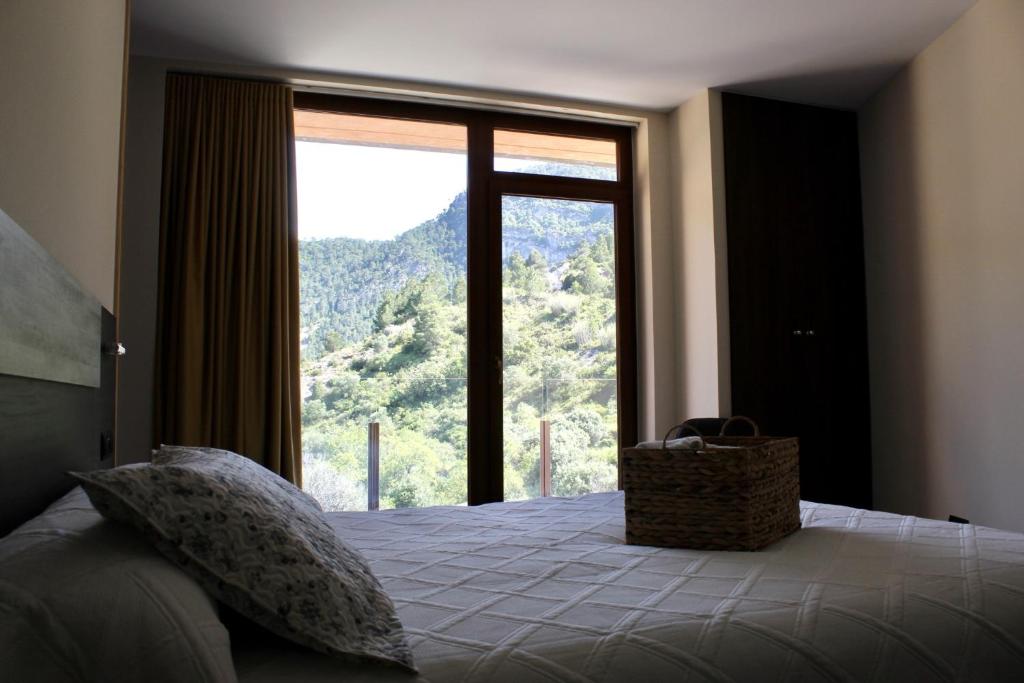 a bedroom with a bed with a large window at Ca L´Ángels in Prat de Compte