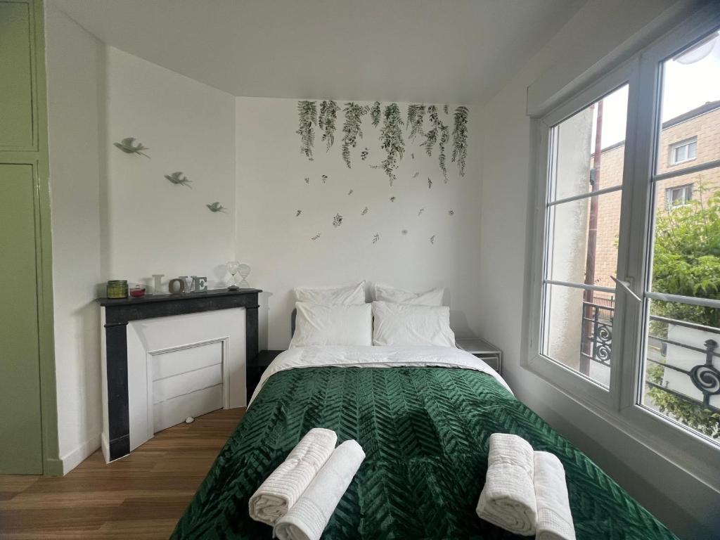 a bedroom with a bed with a green comforter at Modern Renovated Apartment -15 min Orly airport in Viry-Châtillon