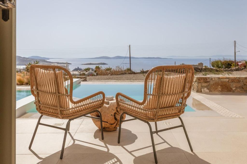 due sedie in rattan sedute accanto a una piscina di Aya Sofia Suites a Mykonos Città