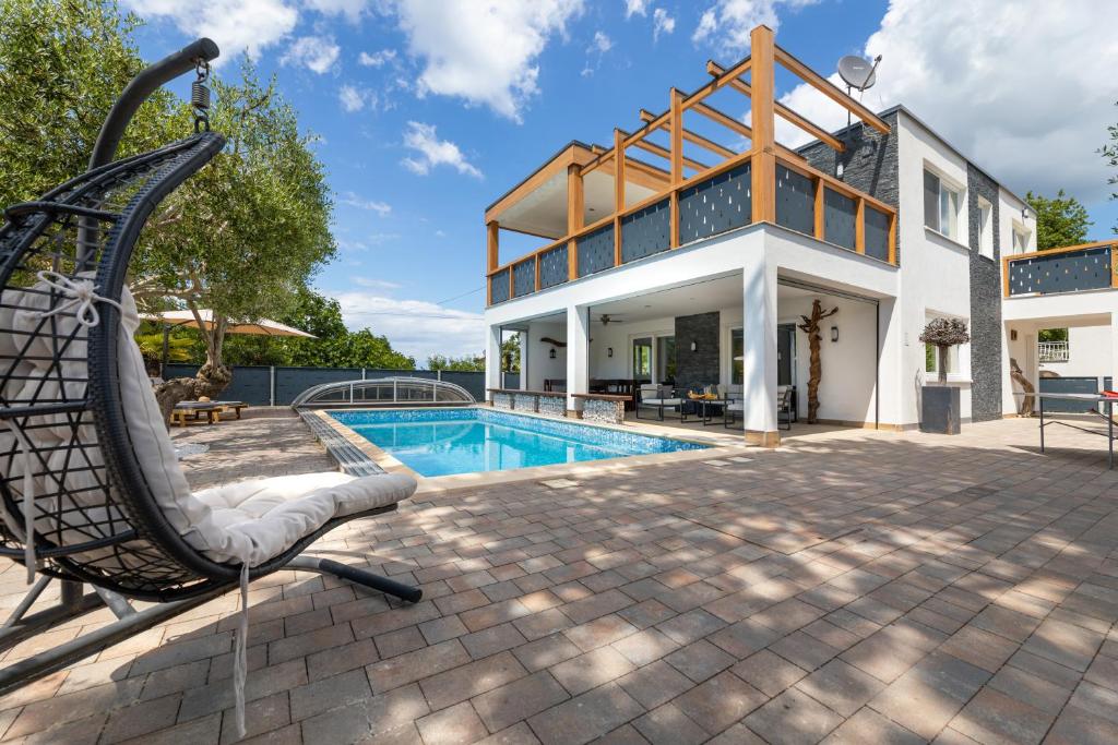 una casa grande con piscina y tobogán en Villa Novum, en Malinska