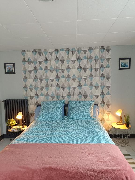 une chambre avec un grand lit avec des oreillers bleus dans l'établissement l'accueil, à Guéron