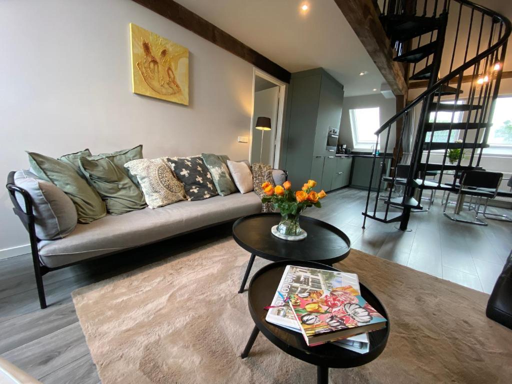 a living room with a couch and a table at Luxe en ruim appartement in Rijksmonument in Vianen