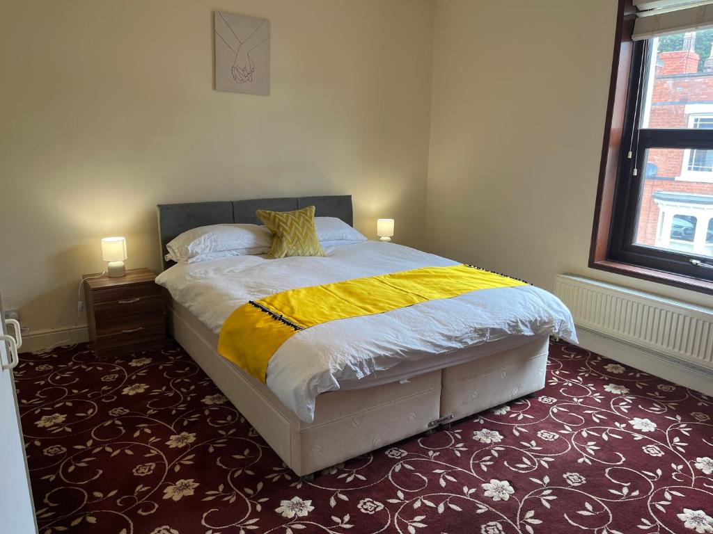 una camera con un letto con una coperta gialla e bianca di Amazing Entire Home in Wolverhampton a Wolverhampton