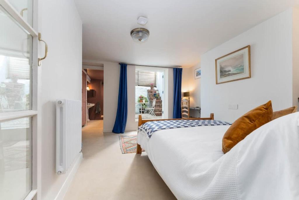 a bedroom with a large bed with blue curtains at Lovely Flat Ensuite Bathroom Private Courtyard in Brighton & Hove