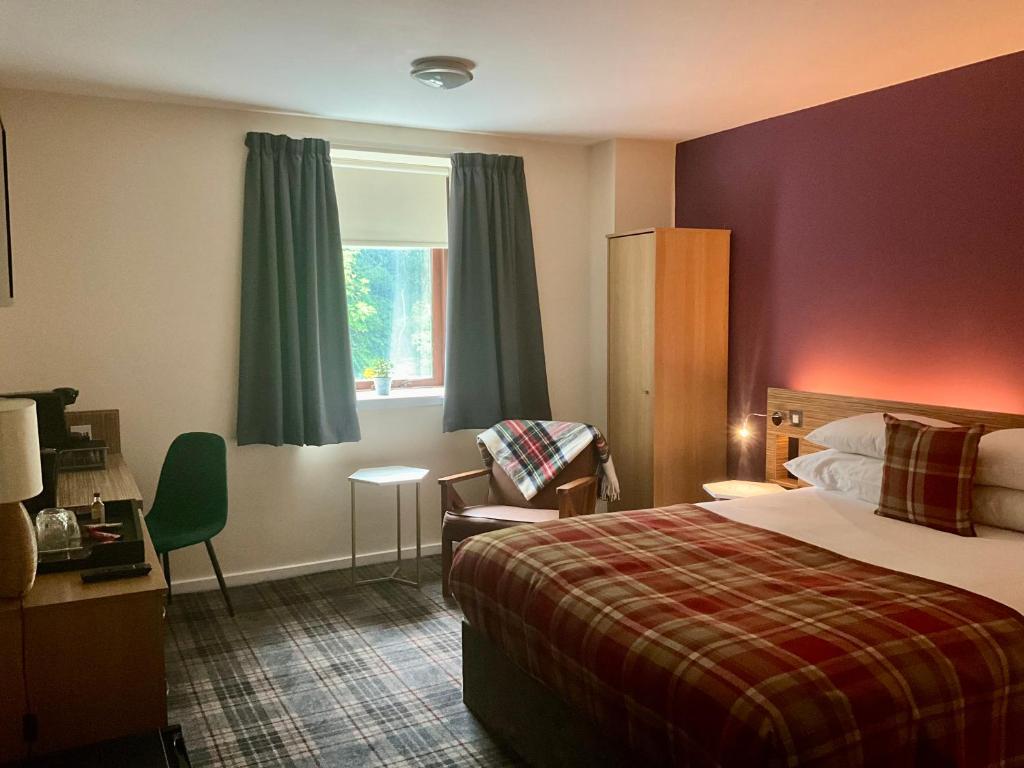 Pokój hotelowy z łóżkiem, krzesłem i oknem w obiekcie Britannia Edinburgh Hotel w Edynburgu