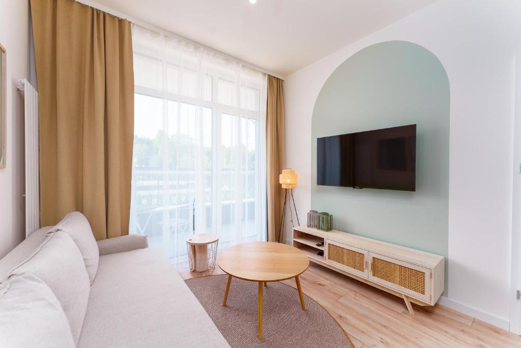a living room with a couch and a table and a tv at Apartament Gaya23 Ku Morzu in Sianozety