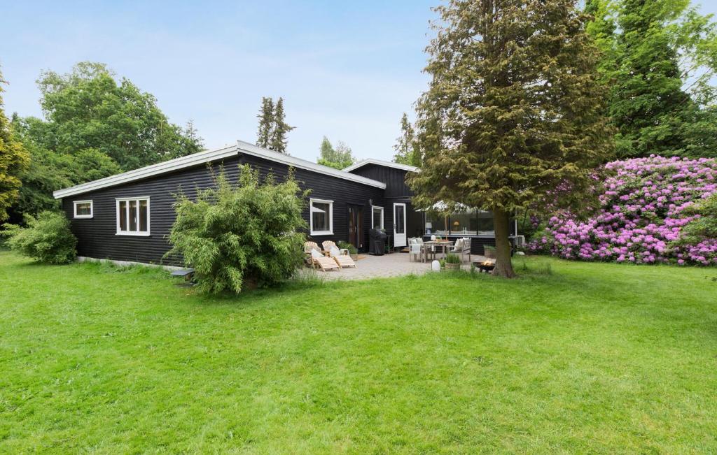 ein schwarzes Haus mit einem Garten davor in der Unterkunft Stunning Home In Hornbk With Kitchen in Hornbæk