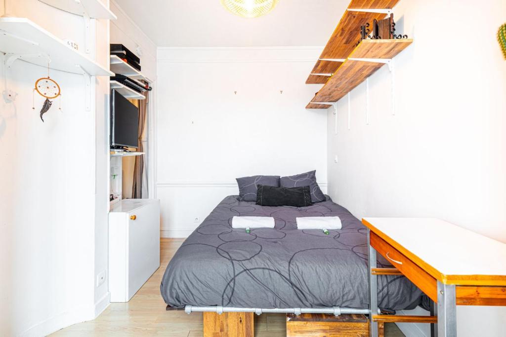 een slaapkamer met een bed en een bureau. bij GuestReady - Stylish Hideaway near Bercy Parc in Parijs