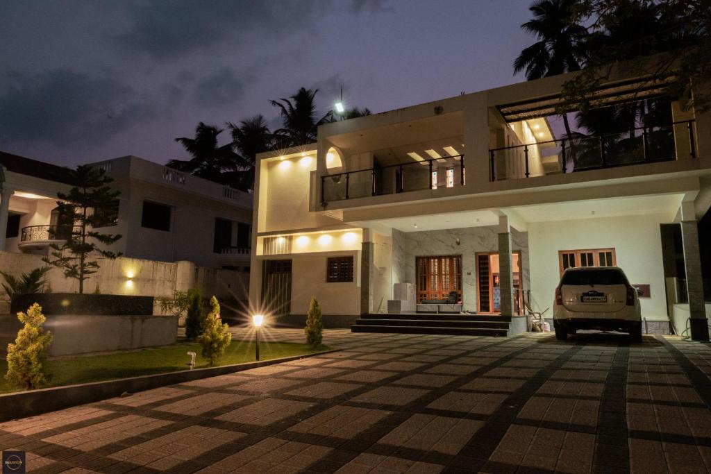 a house with a van parked in front of it at Reunion Marina Villa in Udupi