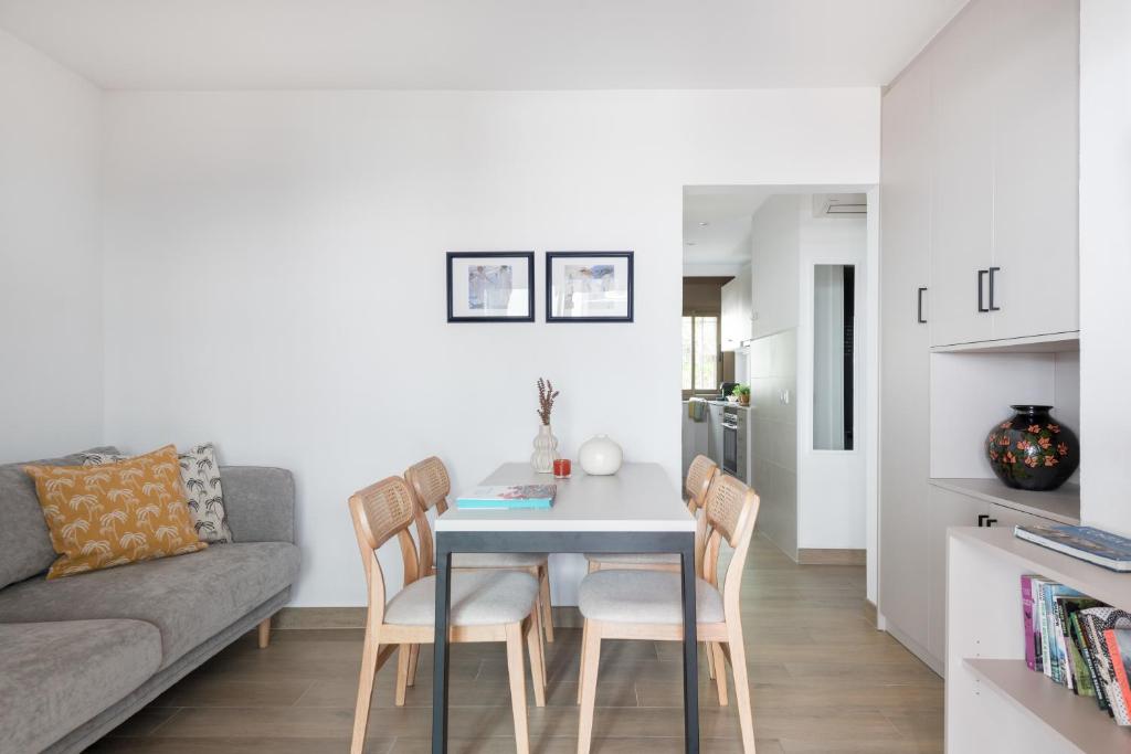 ein Wohnzimmer mit einem Tisch, Stühlen und einem Sofa in der Unterkunft Apartamento Coquette a 50 metros de la playa in Platja  d'Aro