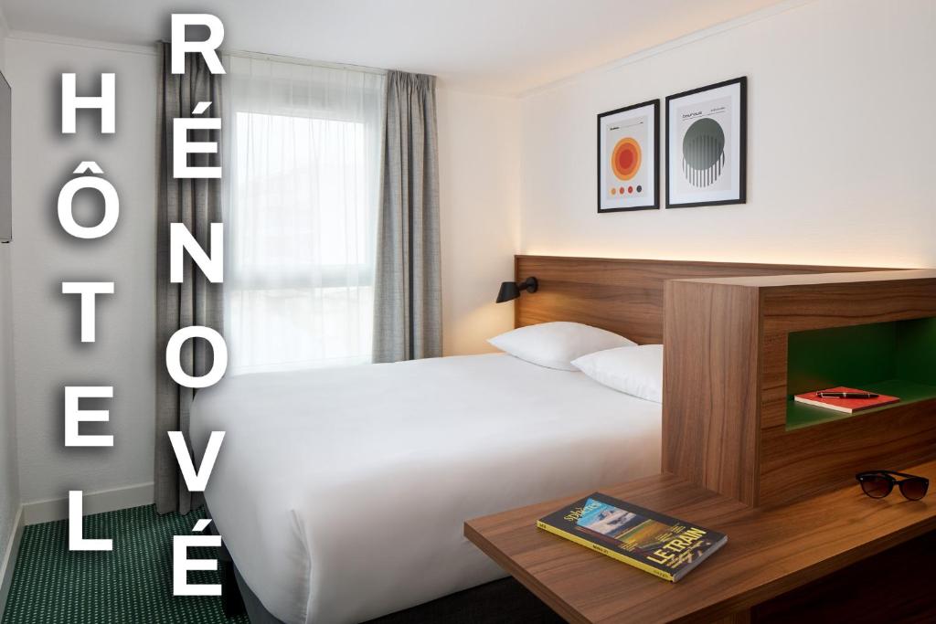 um quarto de hotel com uma cama branca e uma janela em Timhotel Nation em Paris