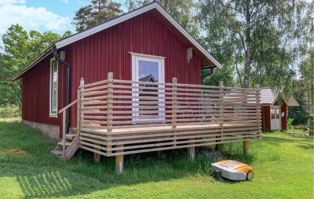 uma pequena casa vermelha com um grande alpendre em madeira em Stunning Home In Sollebrunn With Kitchen em Sollebrunn