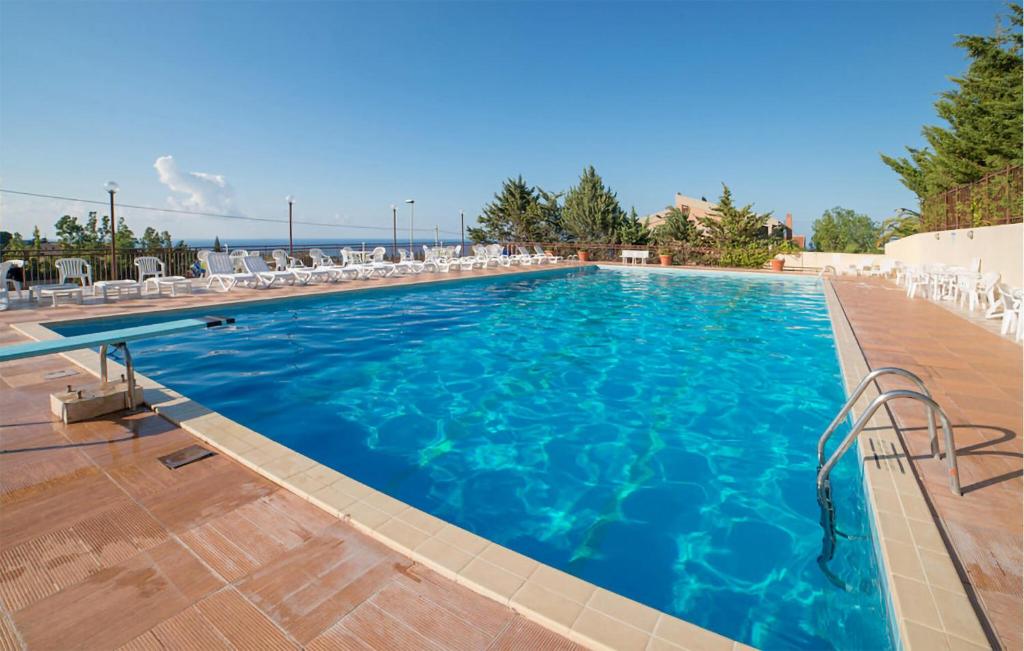 a large swimming pool with chairs and blue water at Awesome Apartment In Trabia in Trabia