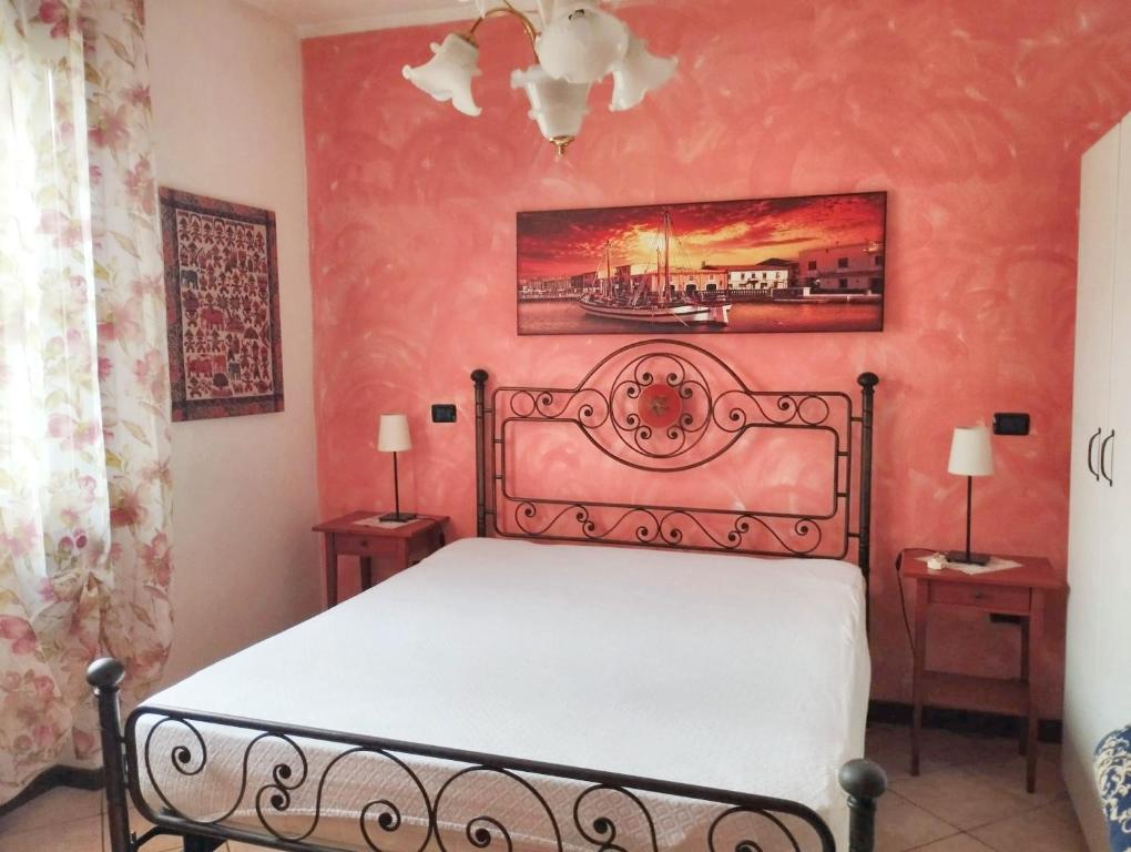 a bedroom with a bed and two tables with lamps at 2 bedrooms apartement with lake view enclosed garden and wifi at San Mauro Pascoli 3 km away from the beach in San Mauro Pascoli