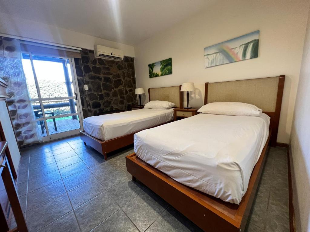 波薩達斯的住宿－Hotel Maitei Posadas，酒店客房设有两张床和窗户。