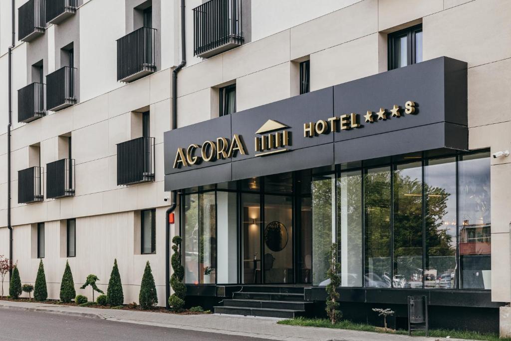 a hotel building with a sign for a hotel at HOTEL AGORA Mures in Târgu-Mureş