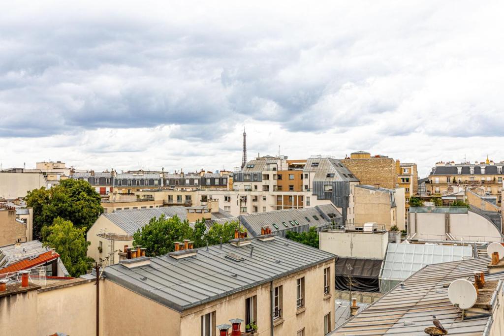 uitzicht op de stad vanaf de daken van gebouwen bij GuestReady - Parisian Perch with Eiffel Tower View in Parijs