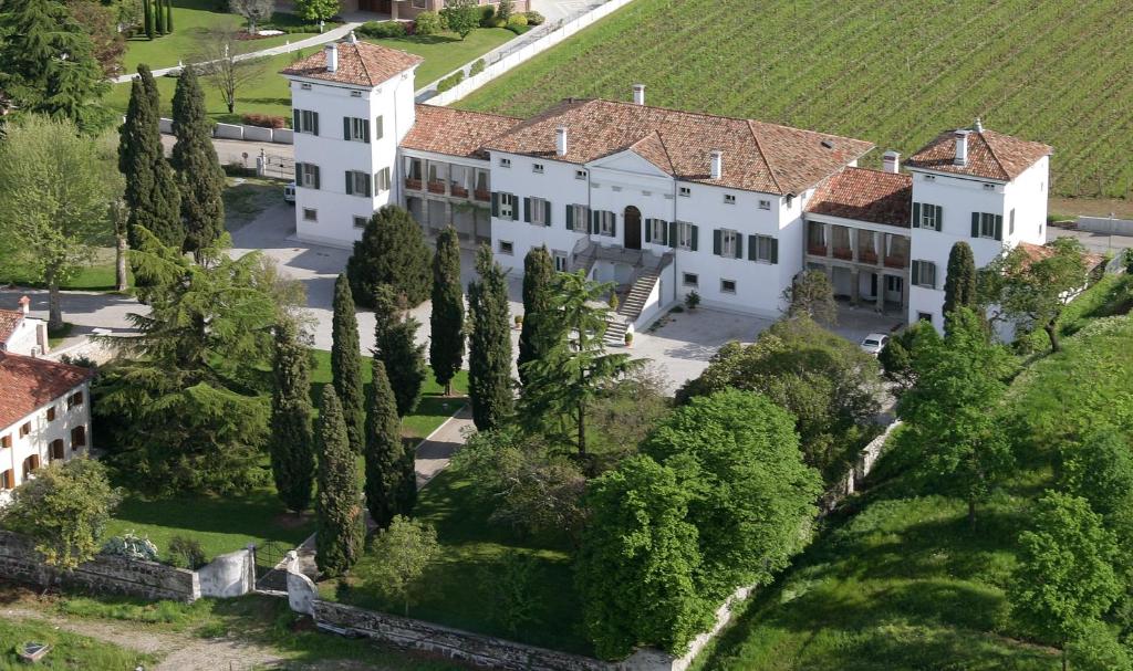 an aerial view of a large white house with trees at Villa Dragoni in Buttrio