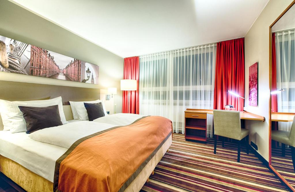 ハンブルクにあるレオナルド ホテル ハンブルク シティ ノードのベッドとデスクが備わるホテルルームです。