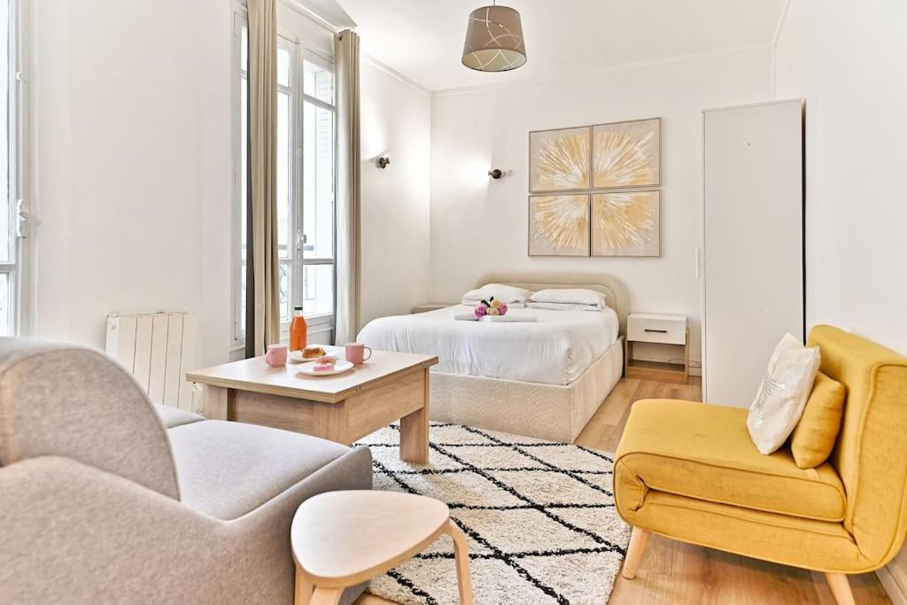 - un salon blanc avec un lit et un canapé dans l'établissement Studio paisible Parc des Buttes-Chaumont, à Paris