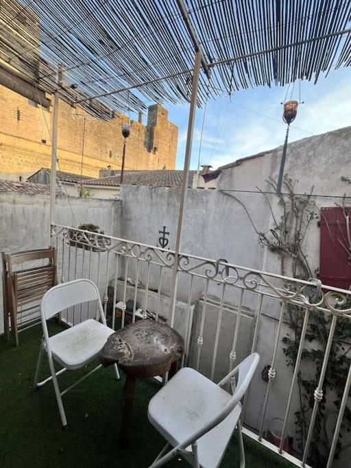 - deux chaises et un parasol sur la terrasse dans l'établissement Intra-muros - balcon et parking, à Aigues-Mortes