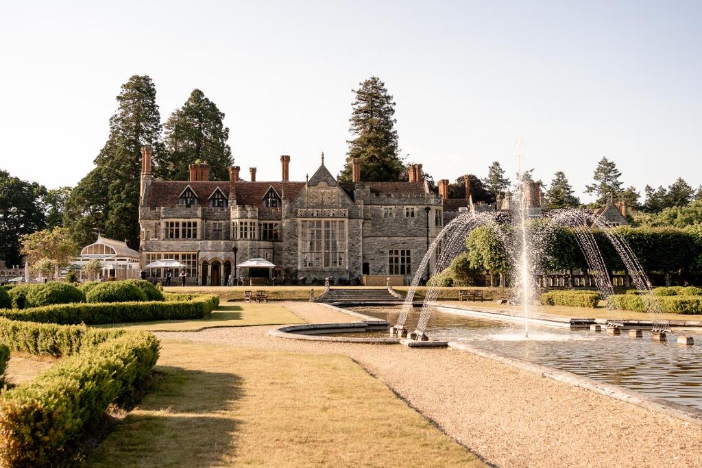 a large mansion with a fountain in front of it at Rhinefield House Hotel in Brockenhurst