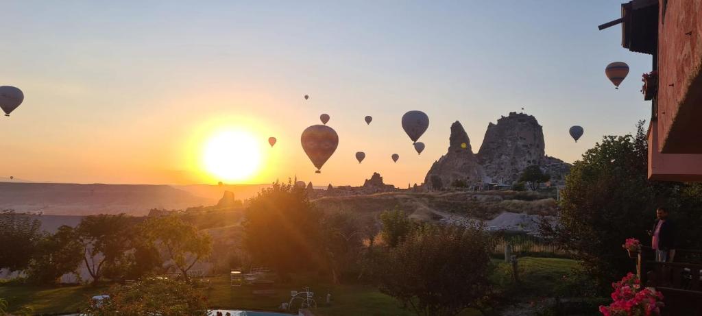 een groep heteluchtballonnen die in de zonsondergang vliegen bij Karlık Evi Hotel - Special Category in Uchisar
