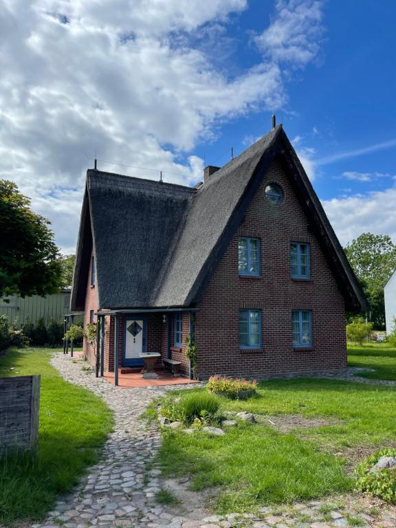 a large brick house with a gambrel roof at Reetdachhäuser gegenüber Hiddensee in Schaprode