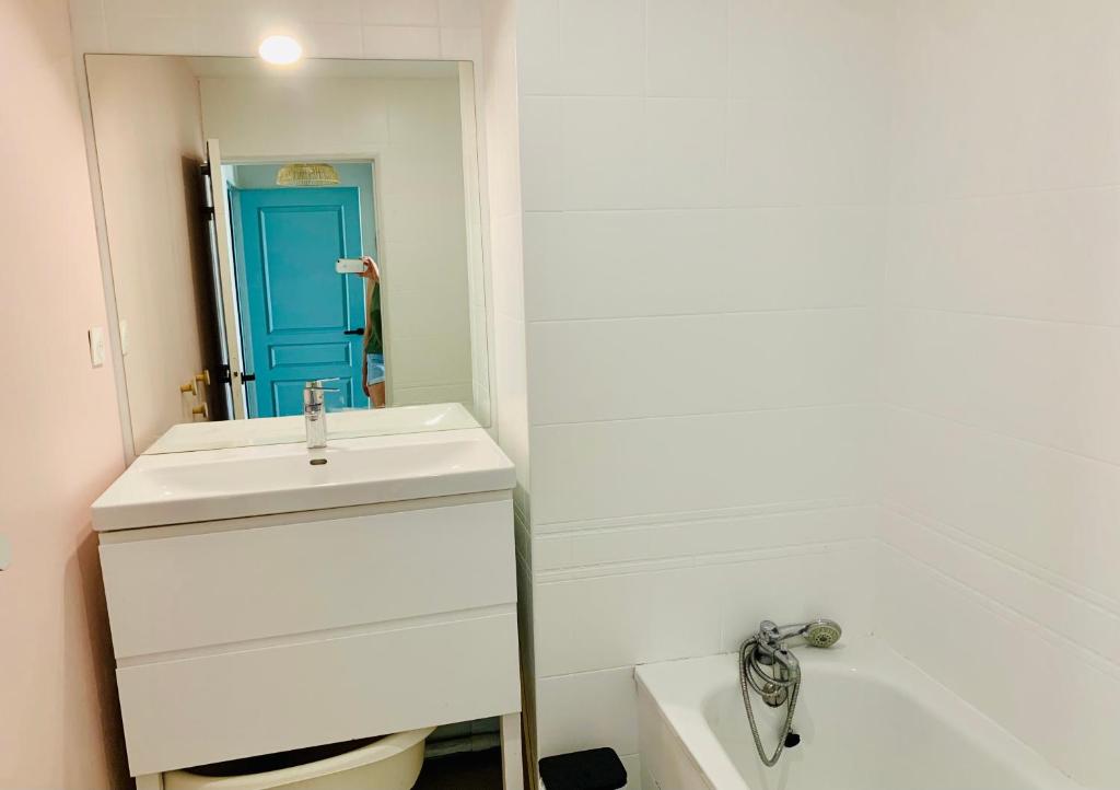 une salle de bain avec un lavabo blanc et un miroir dans l'établissement Très bel appartement rénové, grande terrasse vue mer, à Marseille
