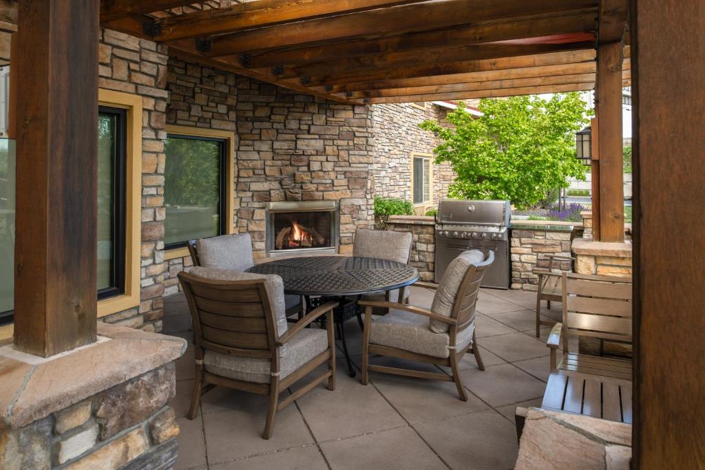 een patio met een tafel en stoelen en een open haard bij TownePlace Suites Richland Columbia Point in Richland