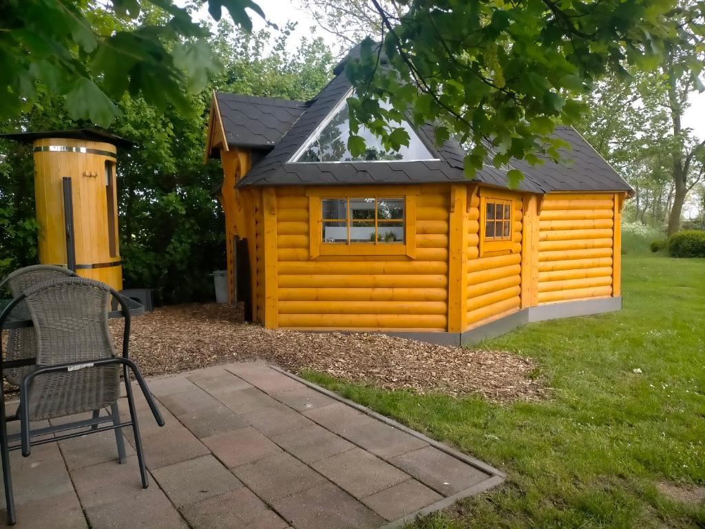 eine kleine gelbe Hütte mit schwarzem Dach in der Unterkunft Sterrenzicht BB Weidszicht in Doezum